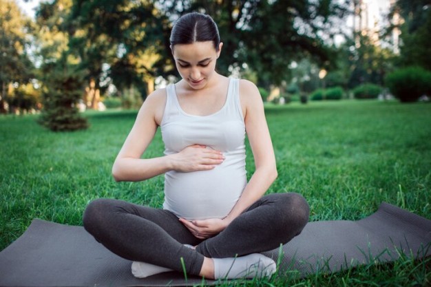Pregnant woman practicing yoga for a healthy pregnancy